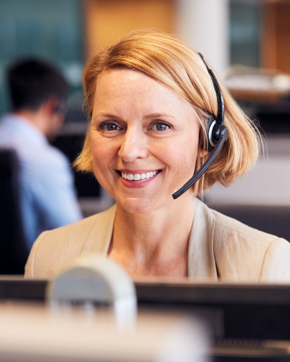 Smiling student enquiries officer on a headset call